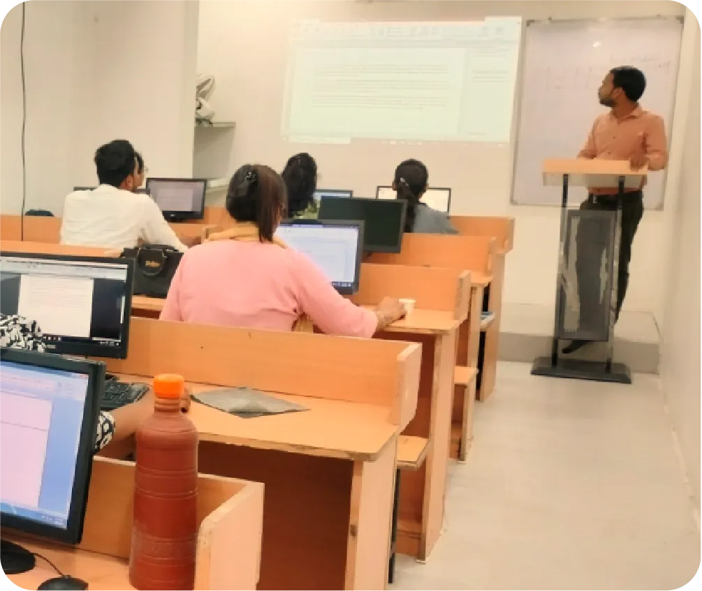 Classroom with students learning practical computer skills as instructor explains concepts on screen